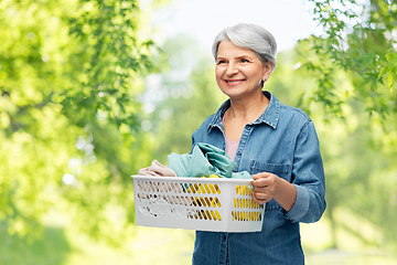 Image showing smiling senior woman with laundry basket