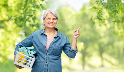 Image showing smiling senior woman with laundry basket