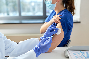 Image showing doctor with syringe vaccinating medical worker