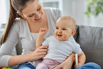 Image showing mother and little baby playing with rattle at home