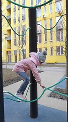 Image showing girl plays on the rope park playground. The concept of children's rest in an urban environment.