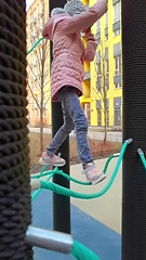 Image showing girl plays on the rope park playground. The concept of children's rest in an urban environment.