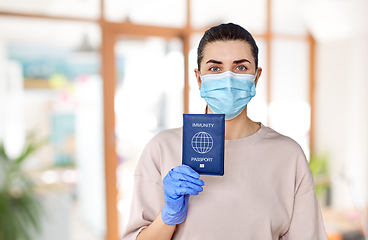 Image showing woman in mask and gloves holding immunity passport