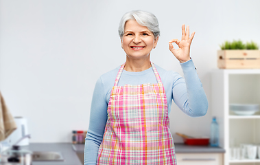 Image showing smiling senior woman showing ok gesture at kitchen