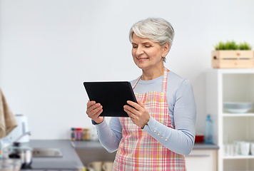 Image showing smiling senior woman with tablet pc at kitchen