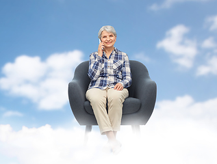 Image showing senior woman calling on smartphone in armchair