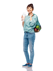 Image showing woman with food in string bag and glass bottle