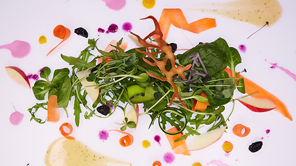 Image showing Mix fresh leaves of arugula, lettuce, spinach, beets for salad on a white background. Selective focus