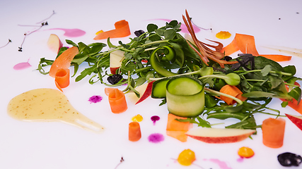 Image showing Mix fresh leaves of arugula, lettuce, spinach, beets for salad on a white background. Selective focus