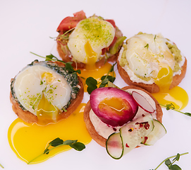 Image showing Four different toasts with poached egg.