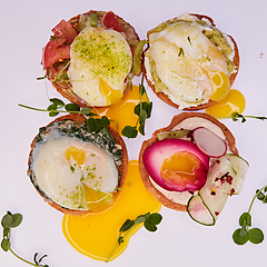 Image showing Four different toasts with poached egg.