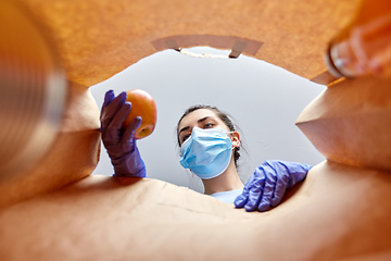 Image showing woman in gloves and mask with food in paper bag