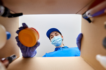 Image showing woman in mask packing parcel box with cosmetics