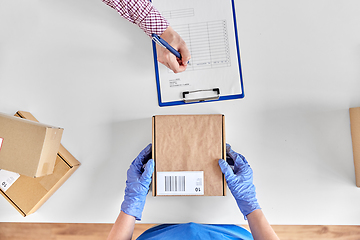 Image showing hands with parcel box and customer signing papers