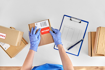 Image showing hands in gloves with returned parcel box