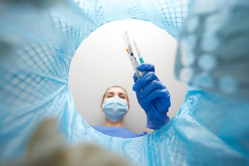 Image showing doctor throwing used syringes into trash can