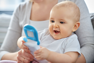 Image showing mother with baby playing with toy phone at home