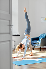 Image showing woman doing yoga exercise on window sill at studio