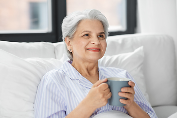 Image showing old woman with cup of coffee in bed at home