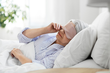 Image showing senior woman with eye sleeping mask in bed at home