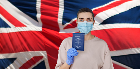 Image showing woman in mask and gloves holding immunity passport