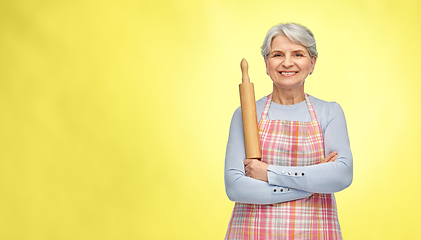 Image showing smiling senior woman in apron with rolling pin