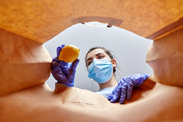 Image showing woman in gloves and mask with food in paper bag