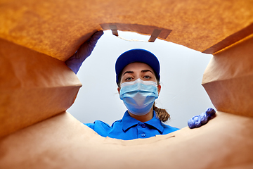 Image showing delivery girl in gloves and mask with food in bag