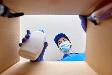 Image showing woman in mask packing parcel box with cosmetics