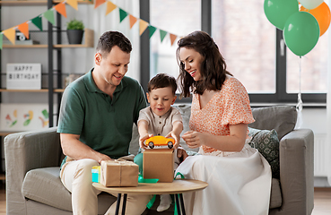 Image showing happy family opening birthday presents at home