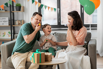 Image showing happy family with gifts and party blowers at home