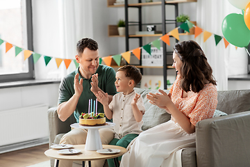 Image showing happy family with birthday cake at home