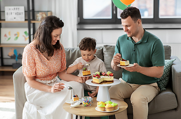 Image showing happy family eating birthday cake at home party