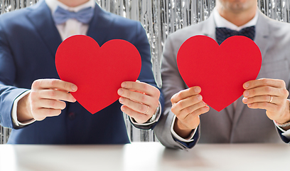 Image showing close up of male gay couple holding red hearts