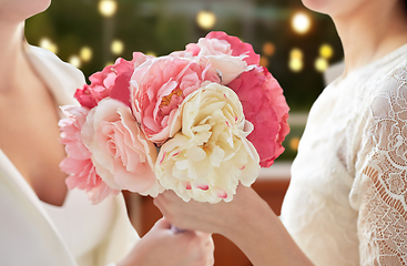 Image showing close up of lesbian couple with flowers at party