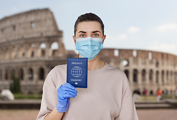 Image showing woman in mask and gloves holding immunity passport