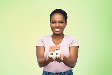 Image showing smiling african american woman holding house model