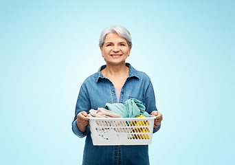 Image showing smiling senior woman with laundry basket