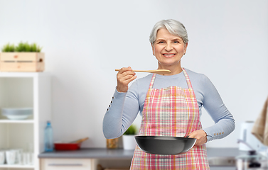 Image showing smiling senior woman with frying pan at kitchen