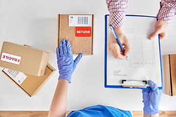 Image showing customer making return of parcel and signing papers