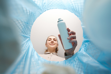 Image showing woman throwing hair spray bottle into trash can