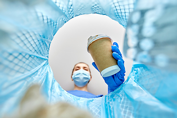 Image showing female doctor throwing coffee cup into trash can