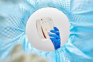 Image showing hand throwing plastic container into trash can