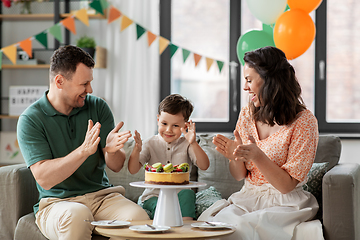 Image showing happy family with birthday cake at home party