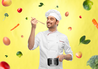 Image showing happy smiling male chef with saucepan tasting food