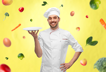 Image showing happy smiling male chef holding empty plate