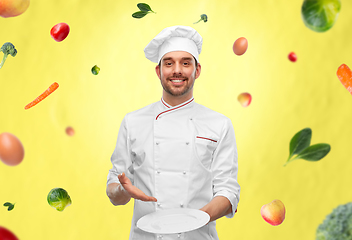 Image showing happy smiling male chef holding empty plate