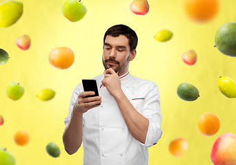 Image showing thinking male chef with smartphone