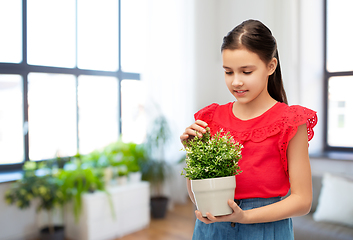 Image showing happy smiling girl holding flower in pot