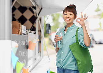 Image showing woman with shopping bag and bottle over food truck